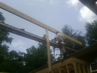 Carpenter setting a ridge beam over a new addition frame — Ice Dam Removal by Roofing Brothers in Lamona