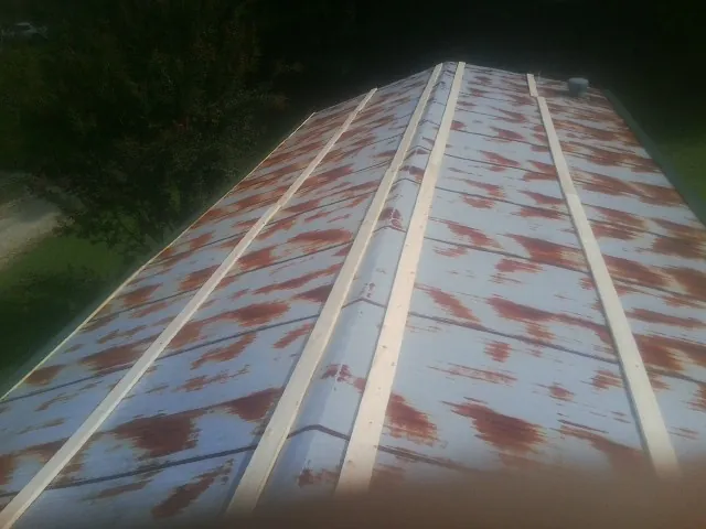 Rusted metal roof panels with new wood purlins before replacement — Storm Damage Roof Repair in Lamona by Roofing Brothers